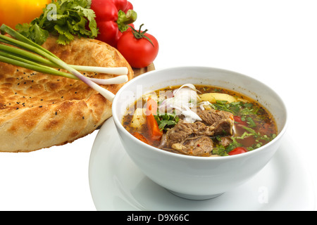 Kharcho soup with bread and vegetables on a white background Stock Photo