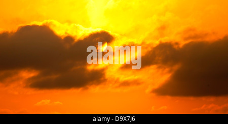 blazing sun shining through haze and clouds Stock Photo