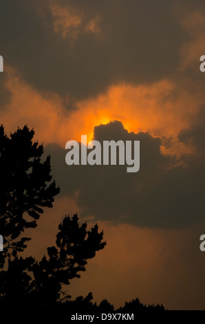 Heavy smoke from the wildfires in Colorado almost obscure the sun, but turn sunset into an eerie orange. Stock Photo