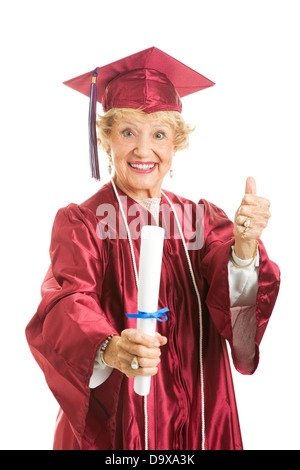 Happy senior lady graduates in her cap and gown, giving thumbs up.  Stock Photo
