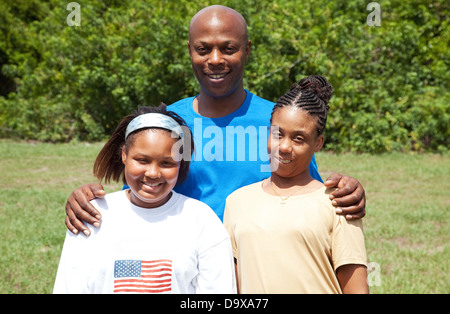 Portrait of a happy, smiling African-american family - father, mother, and daughter. The mother has cerebral palsy.  Stock Photo