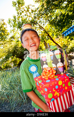 Young boy in birthday hat with presents Stock Photo