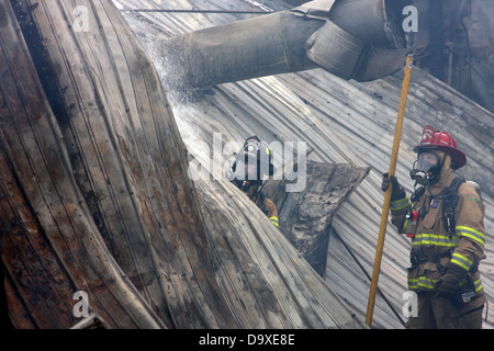Two firefighters extinuishing a fire in a sheet metal building in Wisconsin Stock Photo