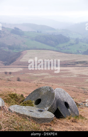 Three circular hewn millstone rocks lie abandoned in a heap overlooking Hathersage Moor, Peak District UK Stock Photo
