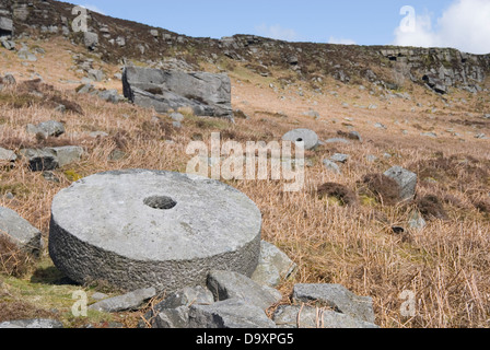 Millstones lie abandoned in situ at the old quarry site at Stanage Edge, Peak District, UK Stock Photo
