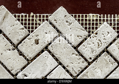 Wall from ornamental decorative stones, under construction on a plastic net. Stock Photo