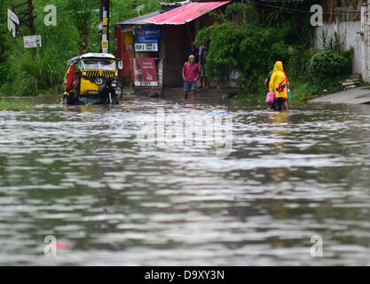 Davao, Philipinnes. 28th June 2013. Filipino residents maneuvers as they try to pass in a flooded road cause by a heavy downpour of rain in Davao city, Southern Philippines, 28 June 2013. According to Philippine Atmospheric Geophysical and Astronomical Services Administration (PAGASA), Storm Signal Number One is raised in areas of Visayas and Mindanao as tropical depression 'Gorio' enters Philippine territory. Credit:  Eli Ritchie Tongo/Alamy Live News Stock Photo