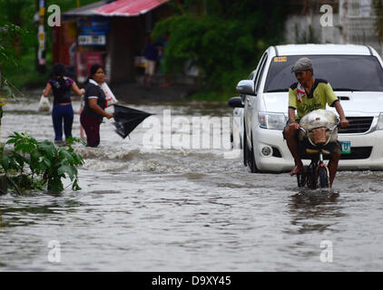 Davao, Philipinnes. 28th June 2013. Filipino residents maneuvers as they try to pass in a flooded road cause by a heavy downpour of rain in Davao city, Southern Philippines, 28 June 2013. According to Philippine Atmospheric Geophysical and Astronomical Services Administration (PAGASA), Storm Signal Number One is raised in areas of Visayas and Mindanao as tropical depression 'Gorio' enters Philippine territory. Credit:  Eli Ritchie Tongo/Alamy Live News Stock Photo