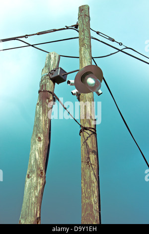 Old lamp on wooden post with security cameras over dark sky Stock Photo