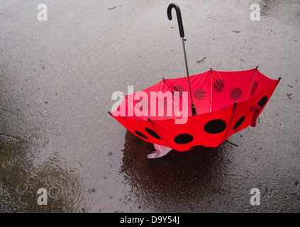 Rainy day photograph with red and black umbrella Stock Photo