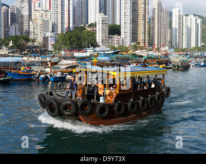 dh  Ap Lei Chau ferry ABERDEEN HONG KONG Aberdeen Harbour sampan high rise residential skyscraper flats boat island Stock Photo