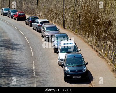 Cars parked next to a curving road in Wirksworth Derbyshire England UK Stock Photo