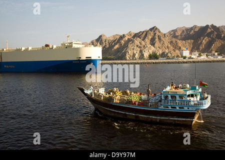 Dhows of traditional design are used for cargo runs and strike quite a contrast with mammoth cargo vessels, Muscat Harbor, Oman Stock Photo
