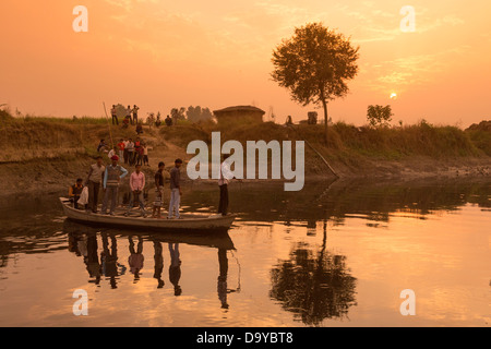 India, Uttar Pradesh, Aligarh, men pulling boat across river via fixed line Stock Photo