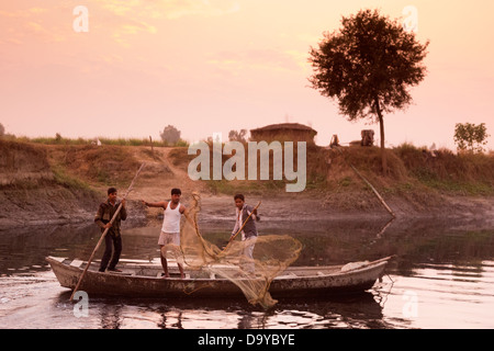 India, Uttar Pradesh, Aligarh men fishing from wooden boat Stock Photo