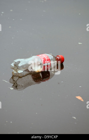 A discarded plastic Coke bottle polluting a canal in Manchester, England, UK Stock Photo