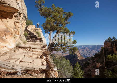 A person in the distance hiking down a steep exposed trail. Stock Photo