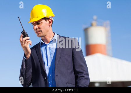 handsome construction manager using walkie talkie outdoors Stock Photo