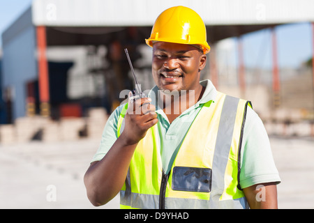 African male builder talking on his radio Stock Photo