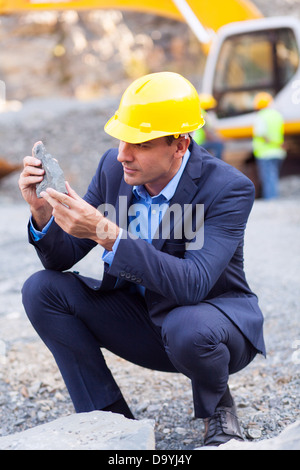mine manager inspecting ore on site Stock Photo