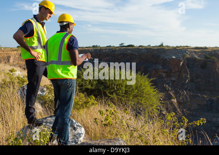 two male surveyors working at mining site Stock Photo