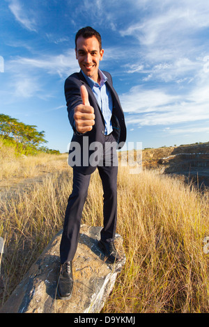 happy young successful businessman giving thumb up outdoors Stock Photo