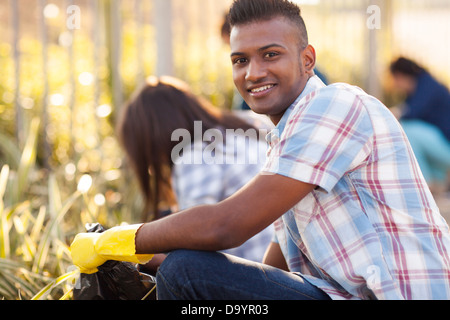 handsome teen volunteer cleaning streets with friends Stock Photo