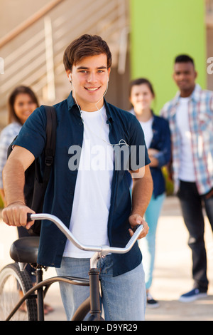 handsome young male teen high school student with a bicycle and friends on background Stock Photo