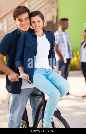 cheerful teenage couple riding a bicycle Stock Photo