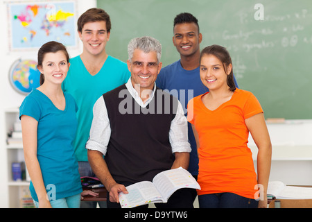 group of cheerful high school students in classroom with senior teacher Stock Photo