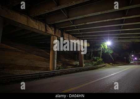 Lonely Street Light Under Highway Bridge At Night Stock Photo