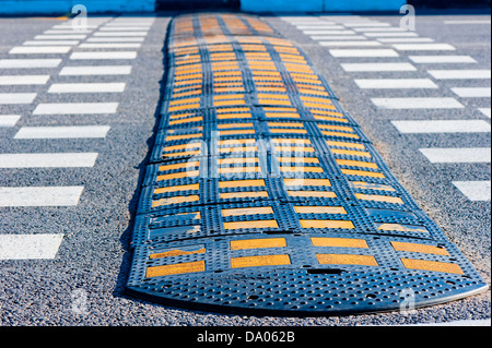 Yellow and Black Speed Bump on asphalt. Stock Photo