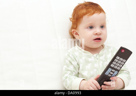 Toddler Baby Watching TV Holding Remote Control Stock Photo