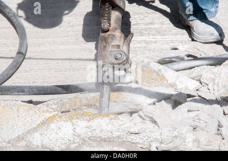 working man breaking the ground with a machine Stock Photo