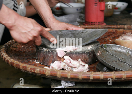 Flower Hmong man cutting meat at the market in Bac Ha, Vietnam, Southeast Asia Stock Photo