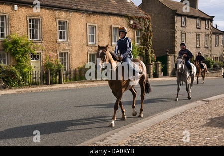 Racehorses being ridden through Middleham, North Yorkshire, on their way to the training gallops. Stock Photo