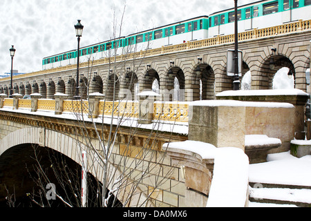 Parisian metro train crossing the bridge over the Sein River by grey winter day Stock Photo