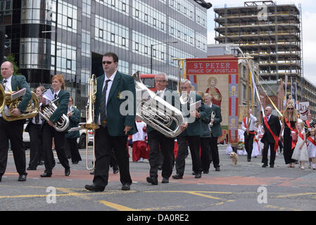 Manchester, UK. 30th June, 2013. A band plays in  front of a banner honouring St Peter in the Madonna Del Rosario Procession through Manchester, which starts from St Michael's Catholic Church in Ancoats and goes through the city centre. Credit:  John Fryer/Alamy Live News Stock Photo