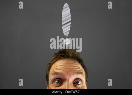 Mans head with chalk exclamation mark on a blackboard. Stock Photo