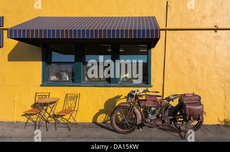 An operational 1914 Harley Davidson motorcycle parked next to a cafe in Davenport, California. Stock Photo
