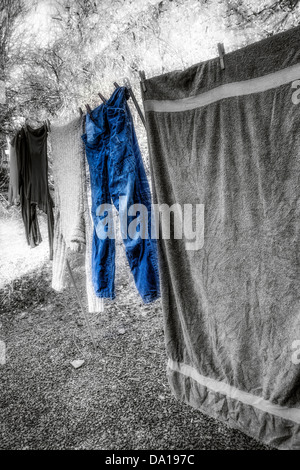 Blue Jeans On A Washing Line - Colour Enhanced against a Black and White back drop, with digitally enhanced glow and blur Stock Photo