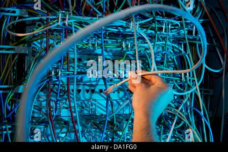 ILLUSTRATION - An illustration dated 01 July 2013 shows a hand working on cables inside a server room in Hanover, Germany. Photo: JULIAN STRATENSCHULTE Stock Photo