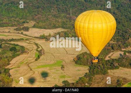 Horizontal aerial view of a hot air balloon inflight and the surrounding countryside near Vang Vieng. Stock Photo