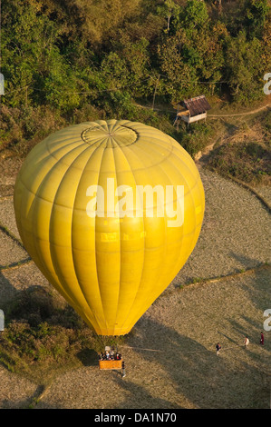 Vertical aerial view of a hot air balloon landing in the countryside near Vang Vieng. Stock Photo