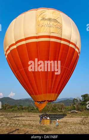 Vertical close up view of a hot air balloon preparing for take off in the countryside near Vang Vieng. Stock Photo