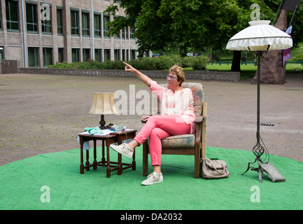 woman sitting in a chair and pointing to something Stock Photo