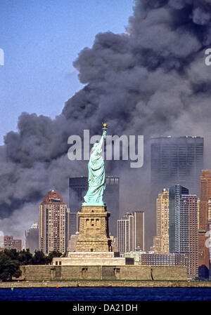 Sept. 11, 2001 - New York, New York, US - The Statue of Liberty stands against the backdrop of billowing clouds of smoke and debris over lower Manhattan after terrorists crashed two hijacked airliners into the World Trade Center on September 11, 2001, bringing down the twin 110-story towers that used to share the skyline. Photograph taken from an abandoned pier in Jersey City, N.J.The Statue of Liberty stands against the backdrop of billowing clouds of smoke and debris over lower Manhattan after terrorists crashed two hijacked airliners into the World Trade Center on September 11, 2001, bringi Stock Photo