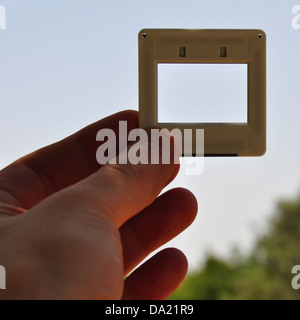 Hand with blank photographic slide picture frame. Place your own image or text. Stock Photo