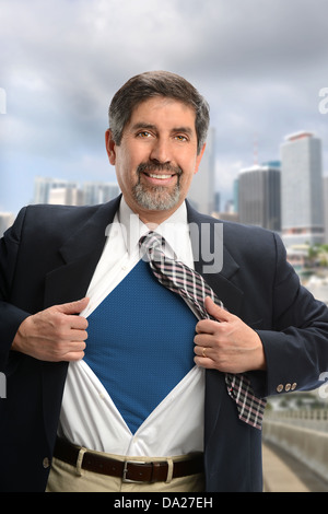 Portrait of super Hispanic businessman opening shirt with buildings in background Stock Photo