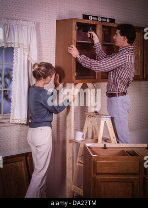 Young couple remodeling kitchen cabinets. Stock Photo